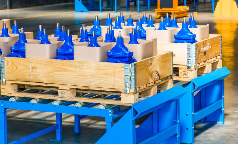 blue industrial valves packaged in wooden cases at valve factory