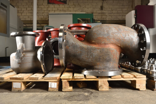cast-iron pipes, bases for creating valves lying on a wooden panel