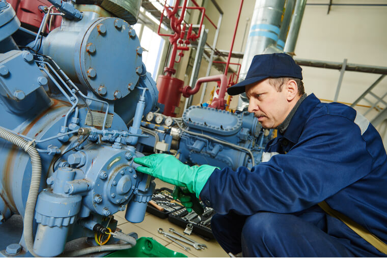 service engineer worker at industrial compressor refrigeration station repairing and adjusting equipment at manufacturing factory